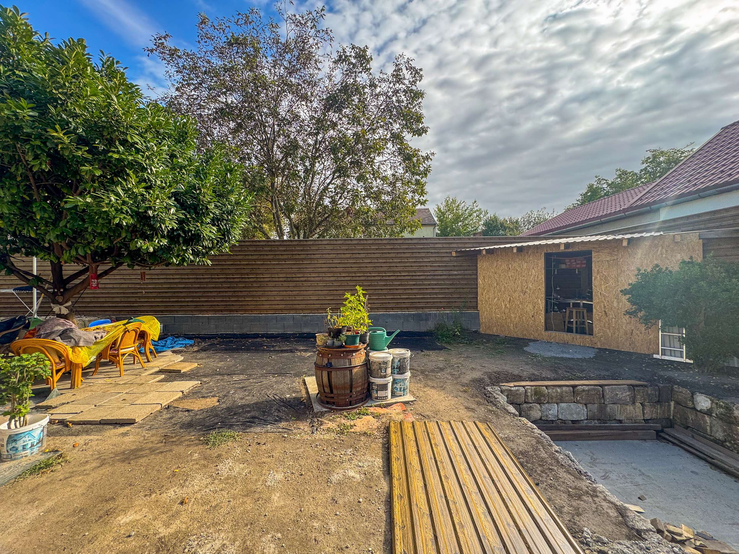 Fahatású trapézlemez kerítés udvarban műhelyépülettel