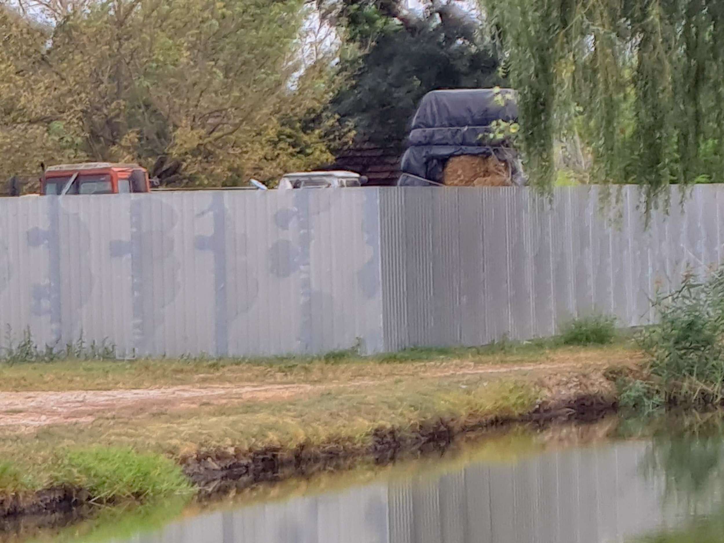 Fehér trapézlemez kerítés tanyaudvarban