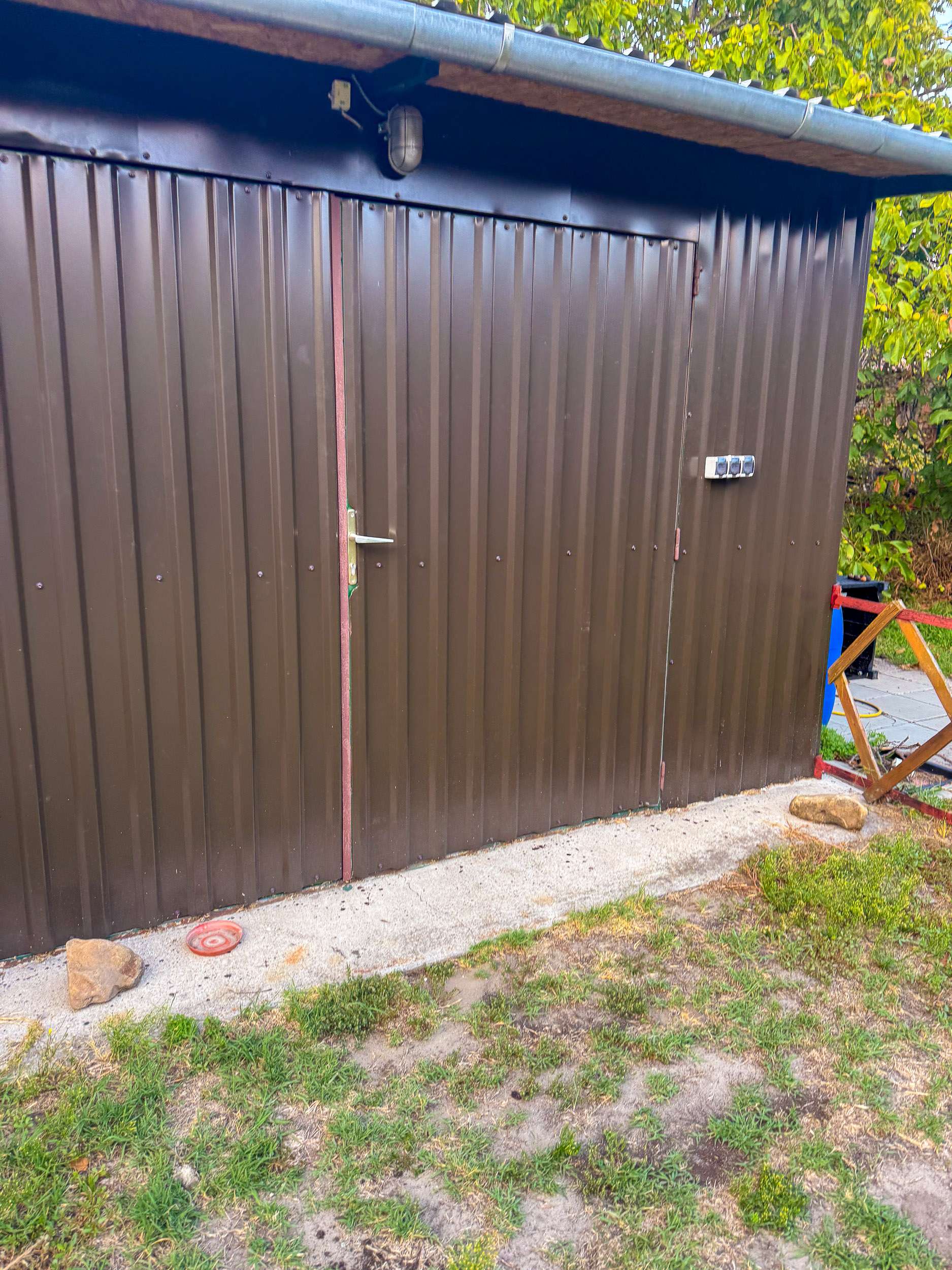 Barna trapézlemez szerszámtároló ajtóval